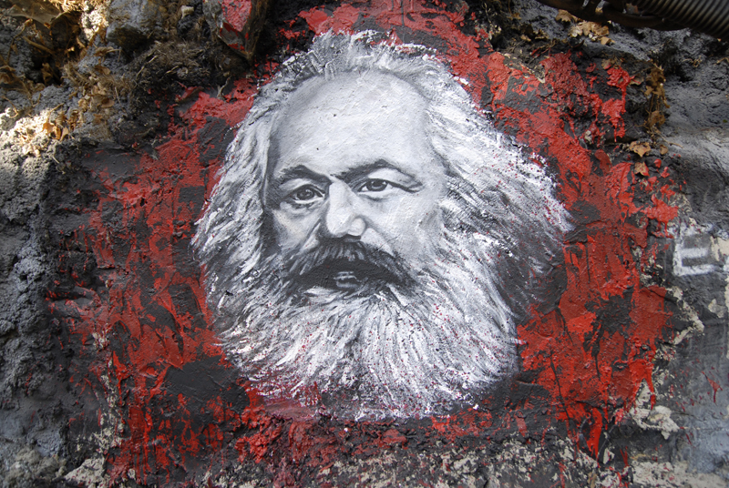 Crédito da imagem: [thierry ehrmann](https://commons.wikimedia.org/wiki/File:Karl_Marx,_painted_portrait_DDC2787.jpg?uselang=pt-br), [CC BY 2.0](https://creativecommons.org/licenses/by/2.0/deed.pt_BR), via Wikimedia Commons.